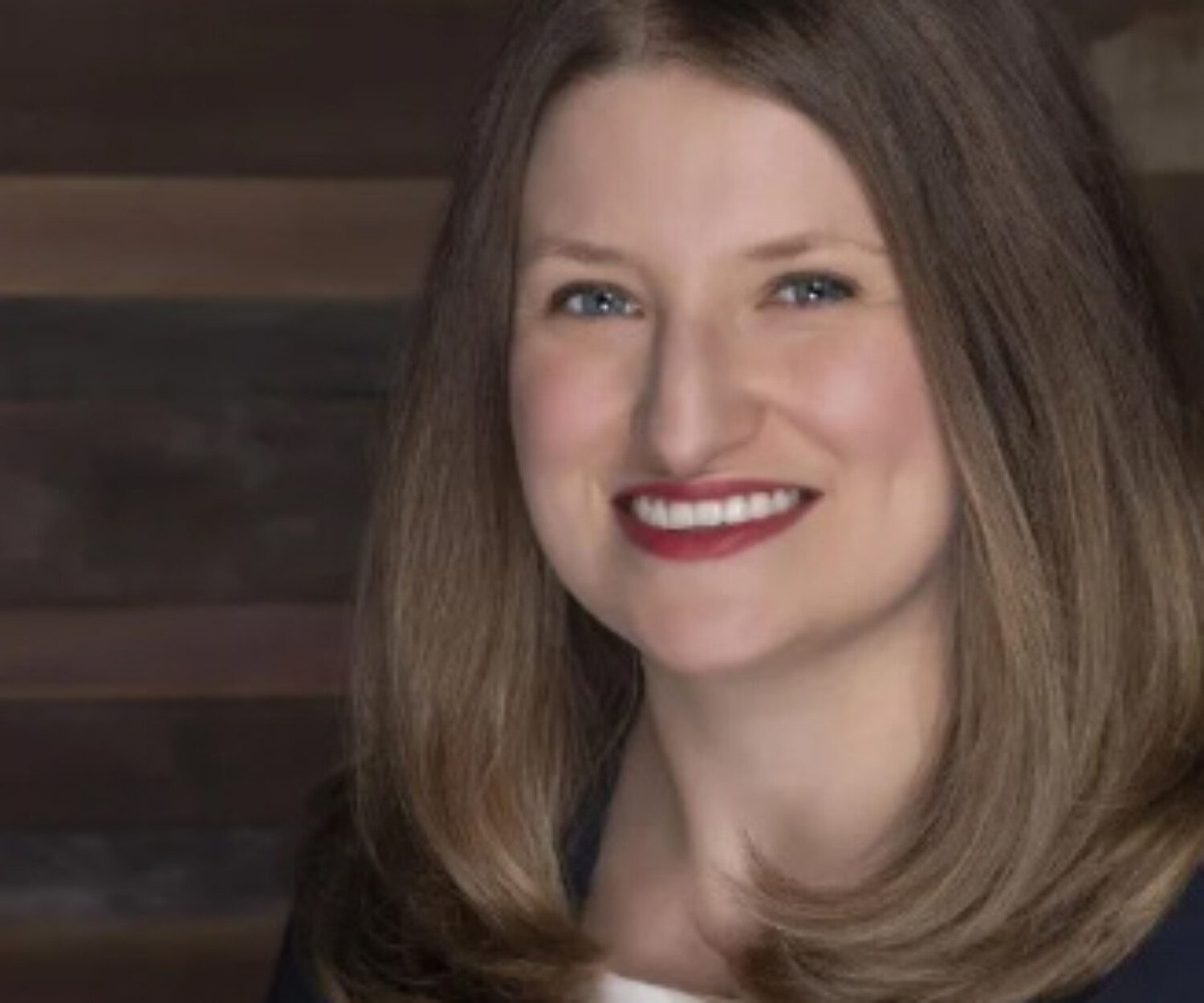 Headshot of a woman against a wooden background