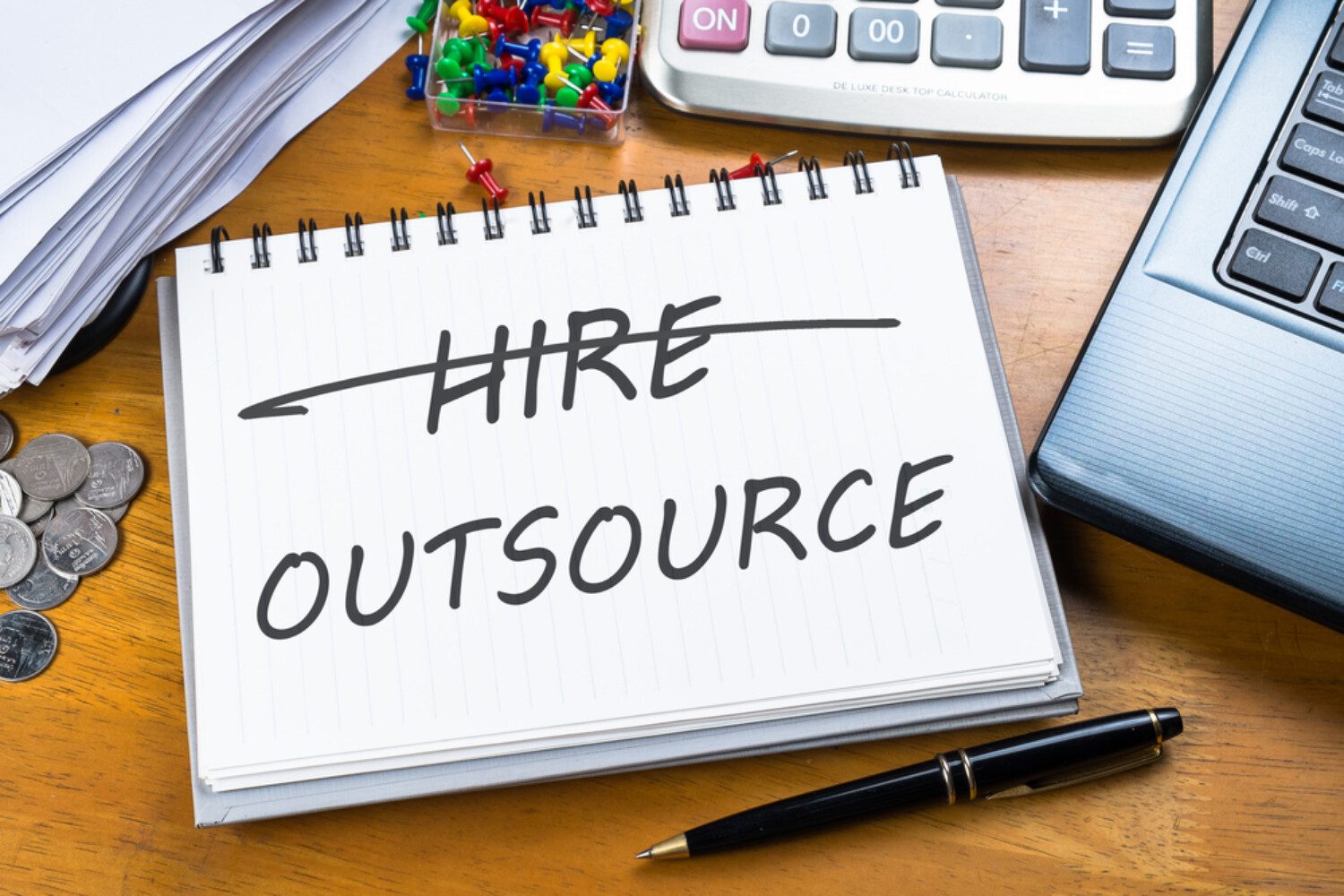 "hire outsource" written on a notepad