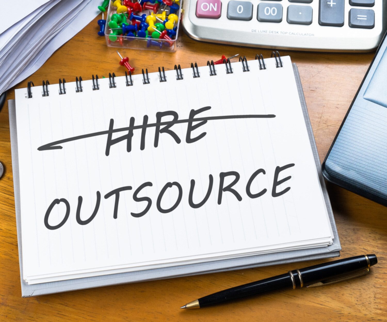 "hire outsource" written on a notepad