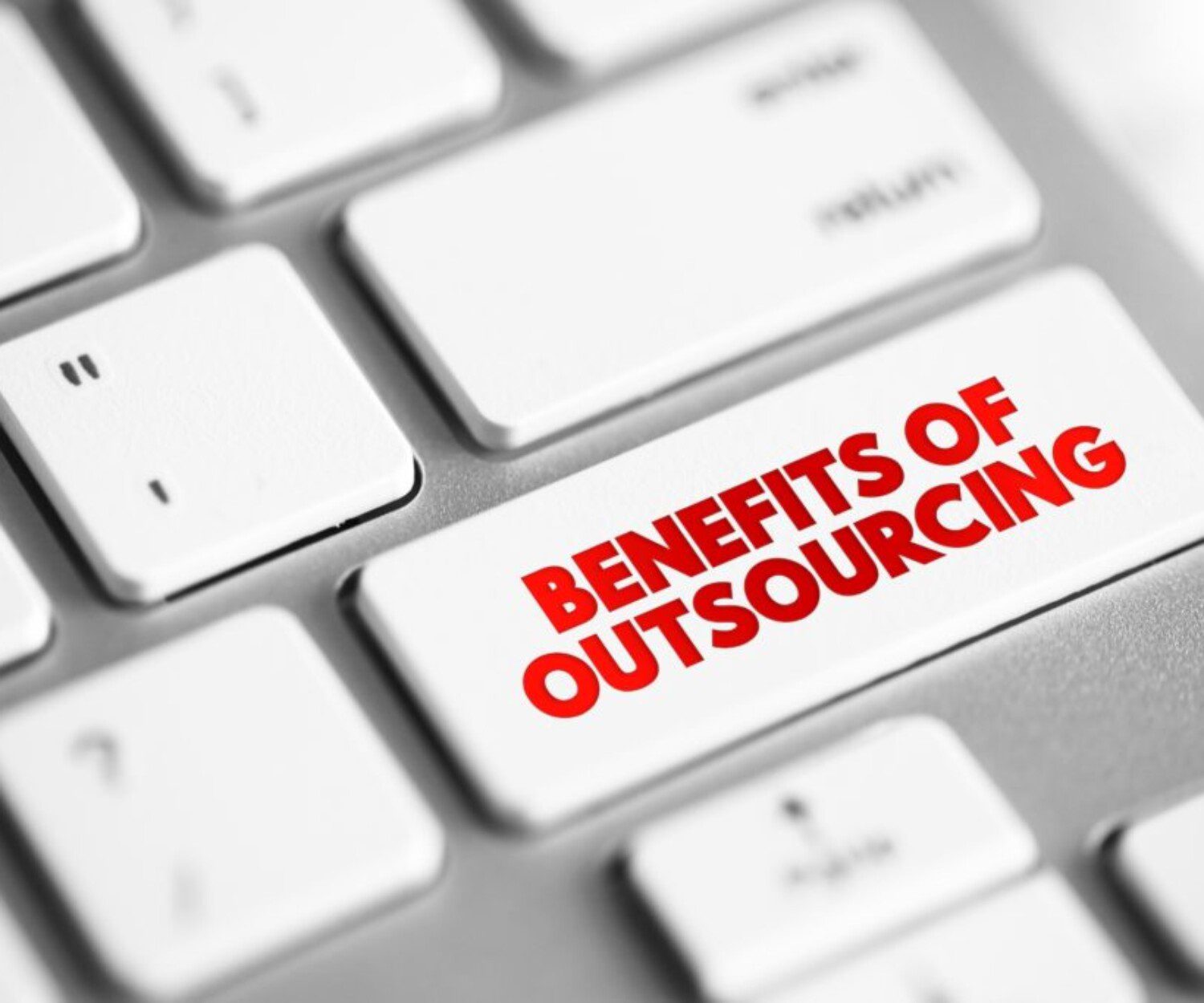 Close up a a keyboard button with "benefits of outsourcing" on it