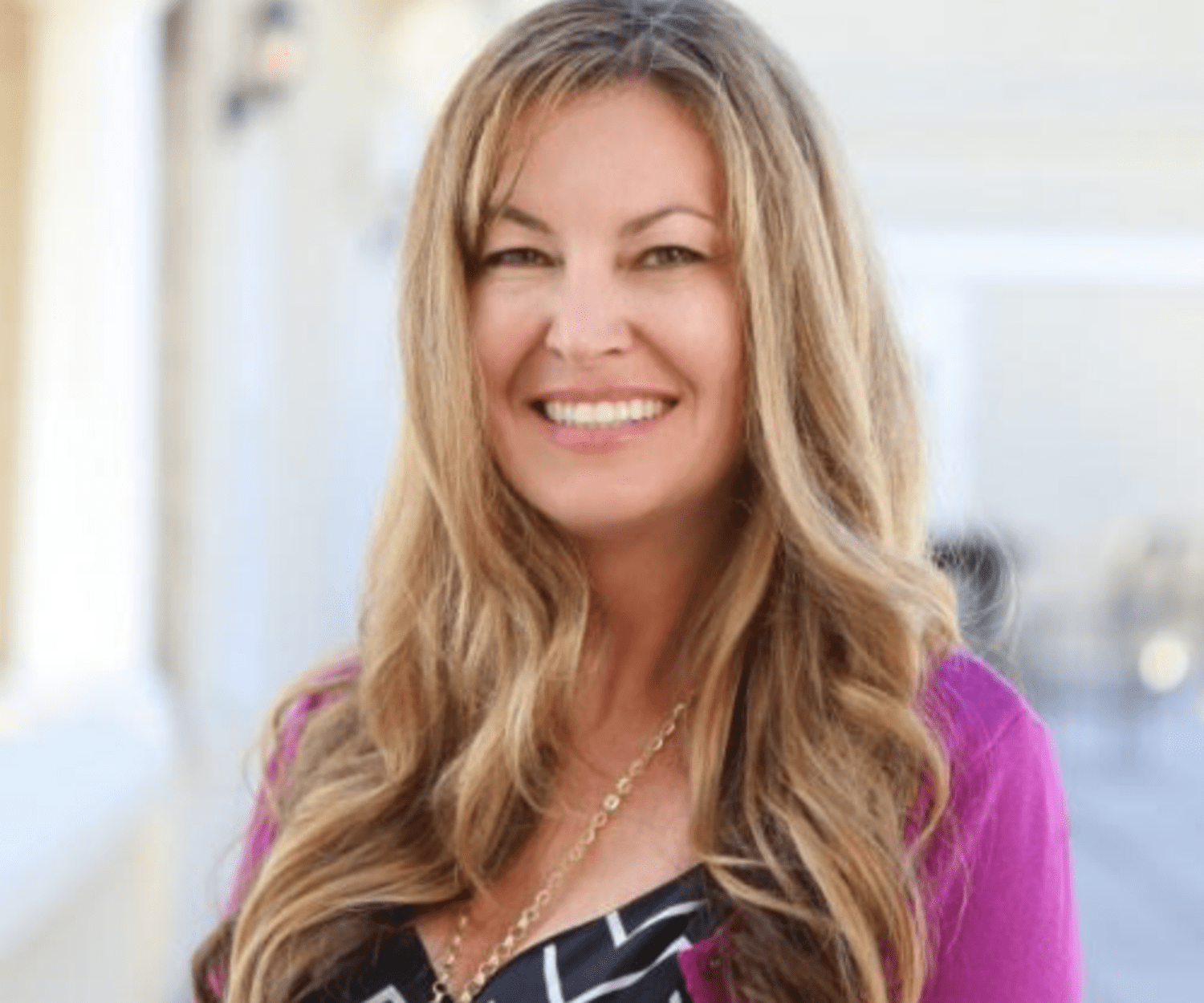 Headshot of a woman in a pink jacket