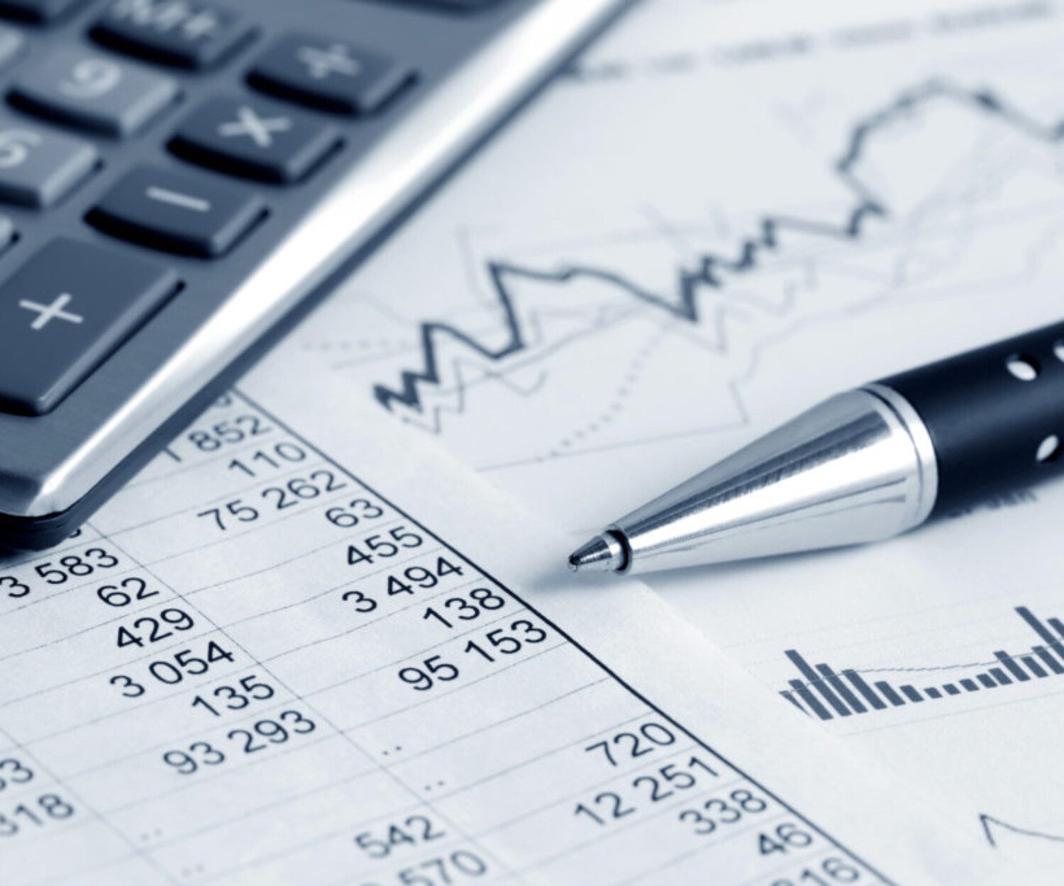 zoomed in on the tip of a pen on top of a spreadsheet of numbers