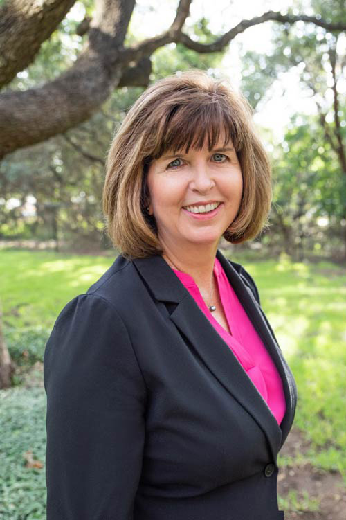 headshot of a woman in a pink shirt outside