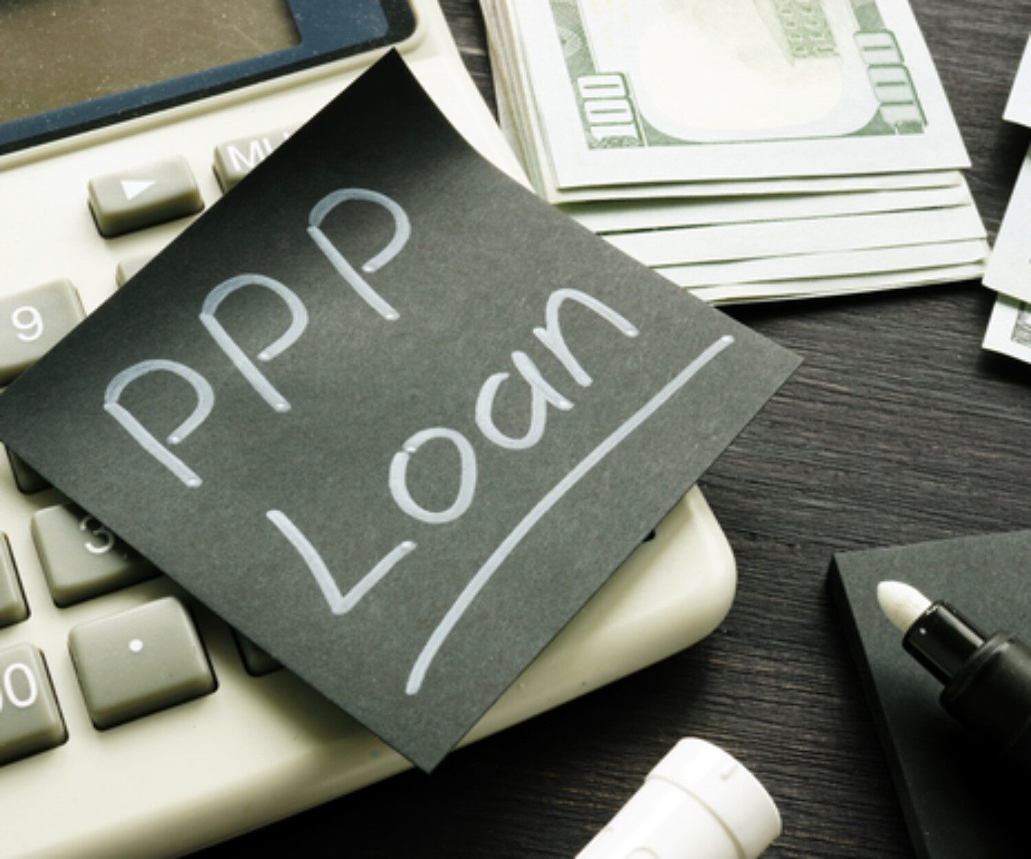 A black sticky note with white text reading "PPP loan"