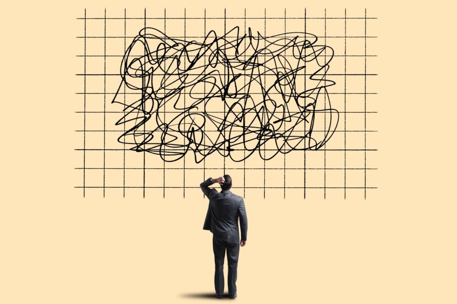 A businessman standing in front of a grid with squiggles on it representing confusion and uncertainty.