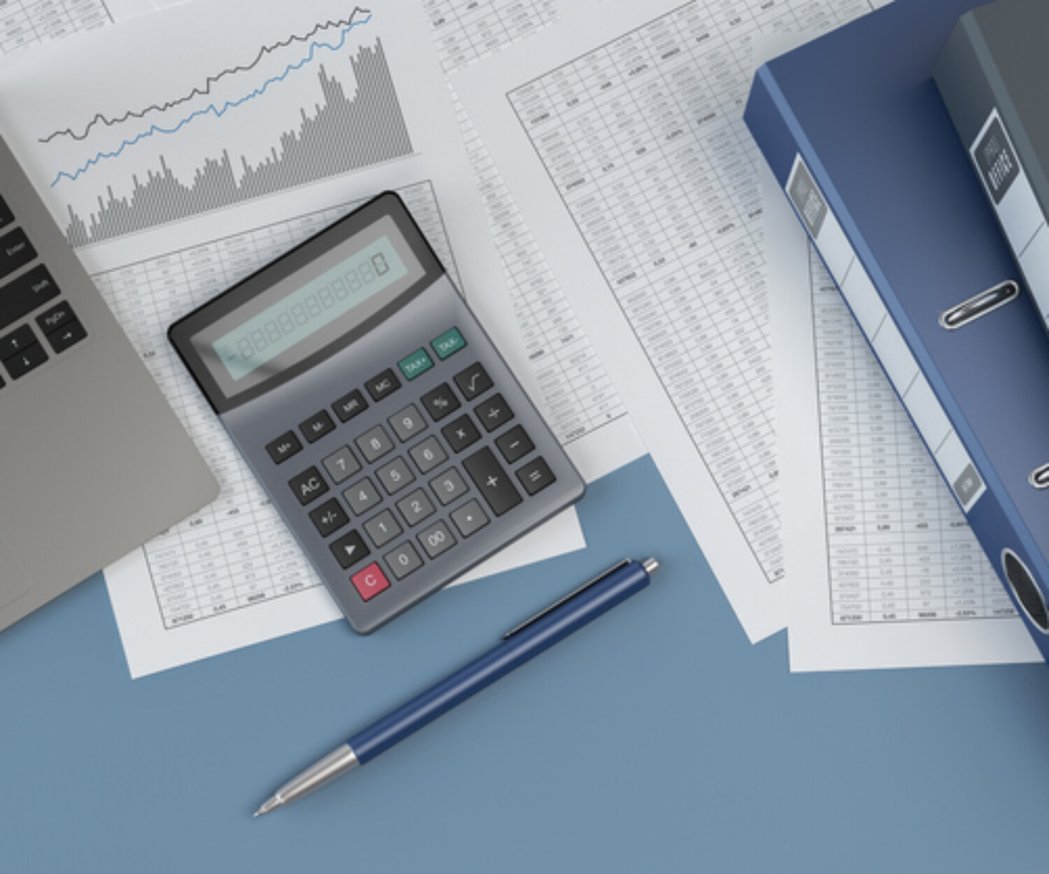 Office workspace with a laptop, calculator, financial documents with charts and tables, blue folders, and a pen on a blue desk.