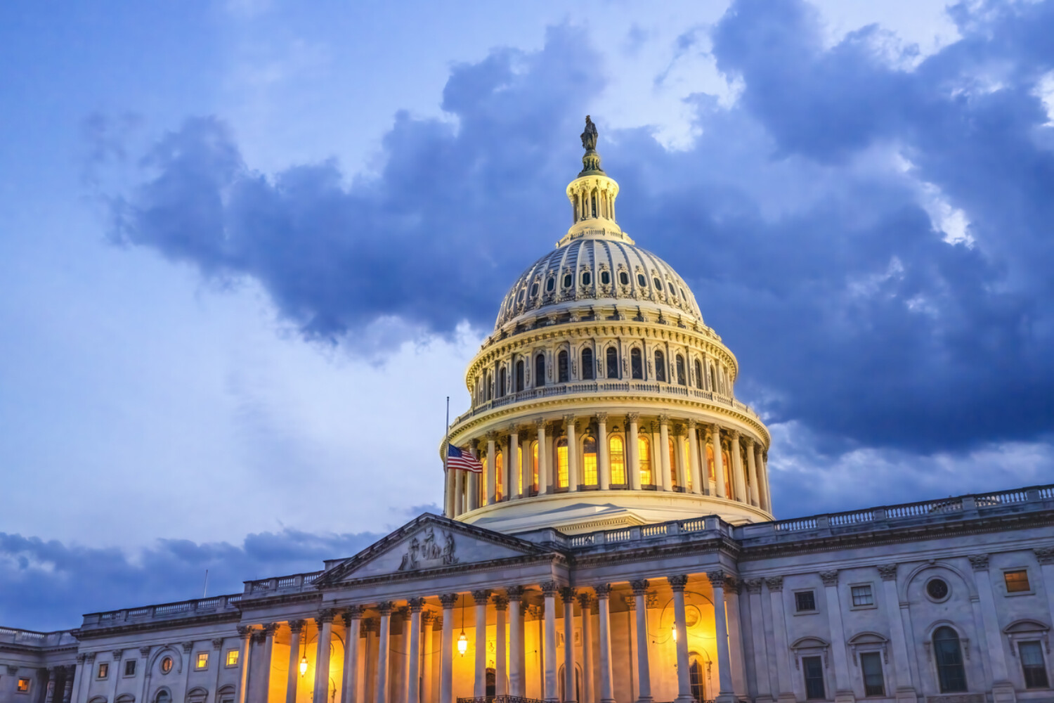 The capitol building in Washington D.C. seen from a low angle agains a cloudy evening sky.