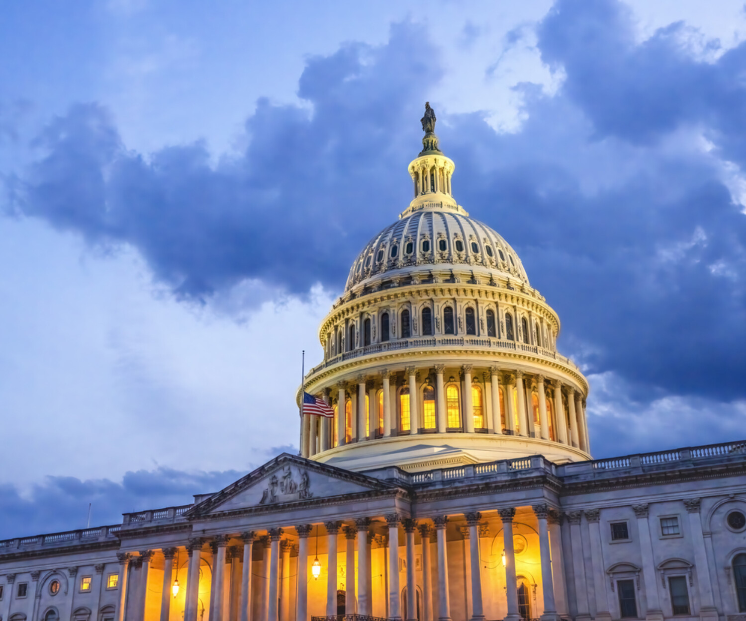The capitol building in Washington D.C. seen from a low angle agains a cloudy evening sky.