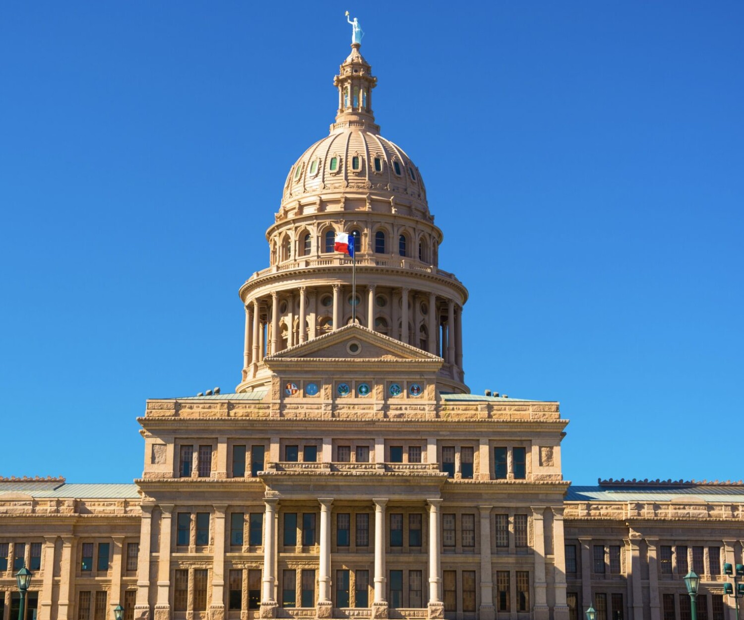The Texas capitol building against a bright blue sky
